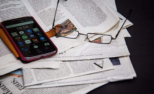newspapers phone and glasses