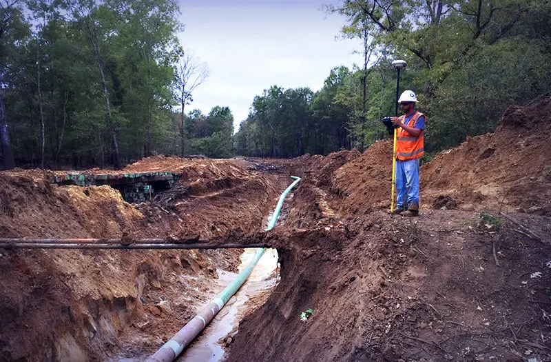 Man surveying land for pipeline installation